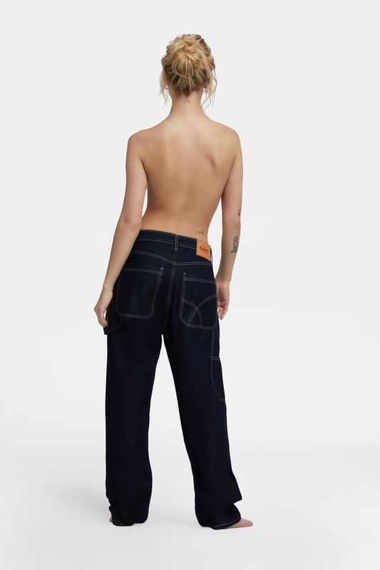 Locker geschnittenes Jeansmodell für Frauen, inspiriert von der Arbeitshose für Männer. Maxi-Seitentaschen, Hammerschlaufe und fließende Stoffe in tiefblauer Waschung, die auch am Abend getragen werden können.