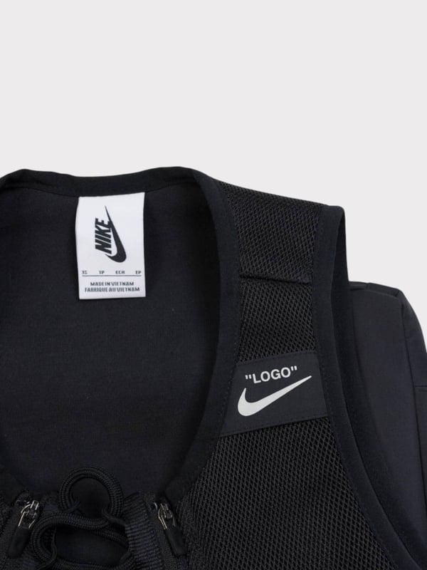 Designer Virgil Abloh uses Nike’s rich track and field heritage to honor the athlete in progress. The Nike x Off-White™ Utility Vest uses Virgil’s iconic sensibilities to deliver a new spin on a classic.Mesh fabric helps provide ventilation.Lace-up closure at the center-front helps secure the fit. An Off-White™ shoe-lace and zippered design allows for easy in and out.A detachable bag at the back is attached through a magnetic fidlock closure. When detached, the bag has a strap for easy carrying.

Embroidered Nike x Off-White™ logo at center front
Body: 100% polyester. Back of Body: 65% cotton/35% polyester. Face of lining: 100% polyester. Back of lining: 65% cotton/35% polyester.