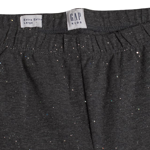 Lange Leggings GAP für Mädchen mit glänzendem Finish und dehnbarem Stoff\n\n Diese GAP Mädchen-Leggings vereinen Komfort und Stil in einem perfekten Alltagsstück. Sie bestehen aus dehnbarem Stoff mit integriertem Glitzer und bieten eine weiche, bequeme Passform, die vollständige Bewegungsfreiheit ermöglicht.\n\n Details:\n Schmale Passform, volle Länge.\n Weicher Stretchstoff mit glänzendem Finish.\n Elastischer Bund für mehr Komfort.\n Taschenloses Design für einen sauberen Look.\n Im gesamten Stoff integriertes Glitzer-Finish.\n\n Bequeme und vielseitige Leggings für Mädchen, ideal, um ihrem Alltagslook einen Hauch von Fantasie zu verleihen.\n Komposition: 96% Baumwolle, 4% Elasthan\n Pflege:\nMit ähnlichen Farben kalt in der Maschine waschen.\n Bei niedriger Temperatur trocknen.\n Bei Bedarf bei mittlerer Temperatur bügeln.