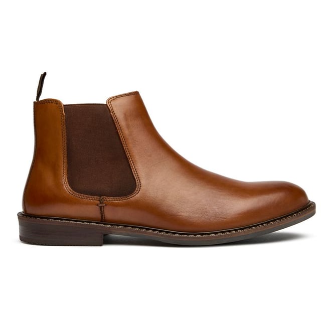 Der Soletrader Steve Chelsea verkörpert zeitlose Eleganz aus hochwertigem, braunem Leder, das mit der Zeit immer schöner wird. Mit einer klassischen runden Zehenform und einer synthetischen Sohle für zuverlässige Griffigkeit, lassen sich diese Stiefeletten dank ihres traditionellen Chelsea-Designs mühelos anziehen. Egal, ob Sie ins Büro gehen oder am Wochenende mit Freunden etwas trinken, der Steve bietet die perfekte Balance zwischen rustikalem Charme und raffinierter Eleganz, die zu allem von maßgeschneiderten Hosen bis hin zu dunklem Denim passt.