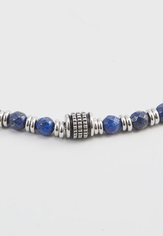 20 cm lange roestvrijstalen armband met lapis lazuli-stenen en stalen stoppers. Gepersonaliseerd label met logo.