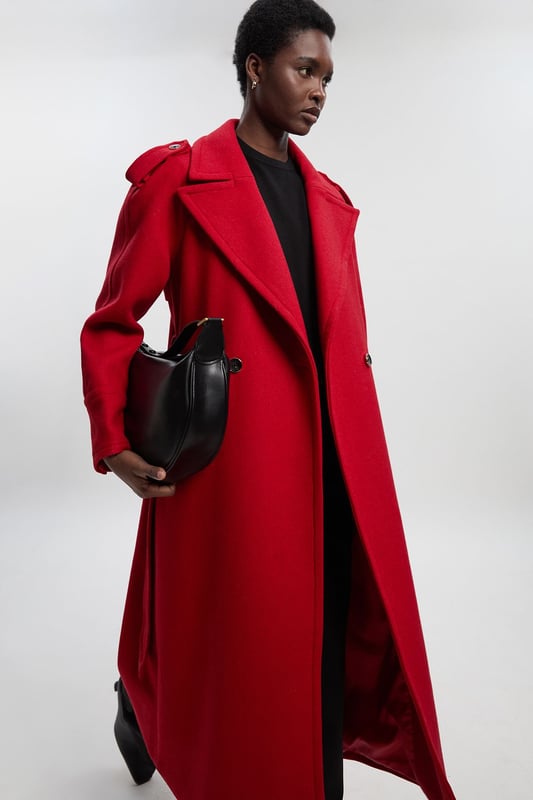 This sophisticated Karen Millen coat combines classic tailoring with contemporary styling for a versatile outerwear option. The belted waist creates a flattering shape that can be cinched or worn more relaxed. The substantial wool blend fabric provides warmth without bulk, making it ideal for autumn through winter wear. Perfect for casual work days or weekend plans, this coat will quickly become your go-to for elevating everyday ensembles. The timeless design ensures it will remain a wardrobe staple for years to come, easily dressed up with boots or down with trainers for truly versatile styling.  Tailored midi coat with elegant belted waist Structured shoulder detailing with decorative epaulettes Classic double-breasted design with statement buttons Wide notched lapels Practical side pockets