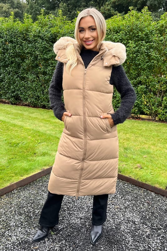 Feel cosy this winter in our Biscuit Faux Fur Hooded Longline Padded Gilet. Featuring a sleeveless design, a super soft beige faux fur hood with removable trim, all over padding, a double sided front zip and front pockets. Simply pair it with your favourite outfits to keep warm and on trend this season. Model wears: UK 8/ EU 36/ US 4 Model's height: 165cm/ 5'5" Approx length from centre back to hem: 110 cm Fabric composition: 100% Polyester Colour: BISCUIT