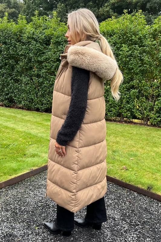 Feel cosy this winter in our Biscuit Faux Fur Hooded Longline Padded Gilet. Featuring a sleeveless design, a super soft beige faux fur hood with removable trim, all over padding, a double sided front zip and front pockets. Simply pair it with your favourite outfits to keep warm and on trend this season. Model wears: UK 8/ EU 36/ US 4 Model's height: 165cm/ 5'5" Approx length from centre back to hem: 110 cm Fabric composition: 100% Polyester Colour: BISCUIT
