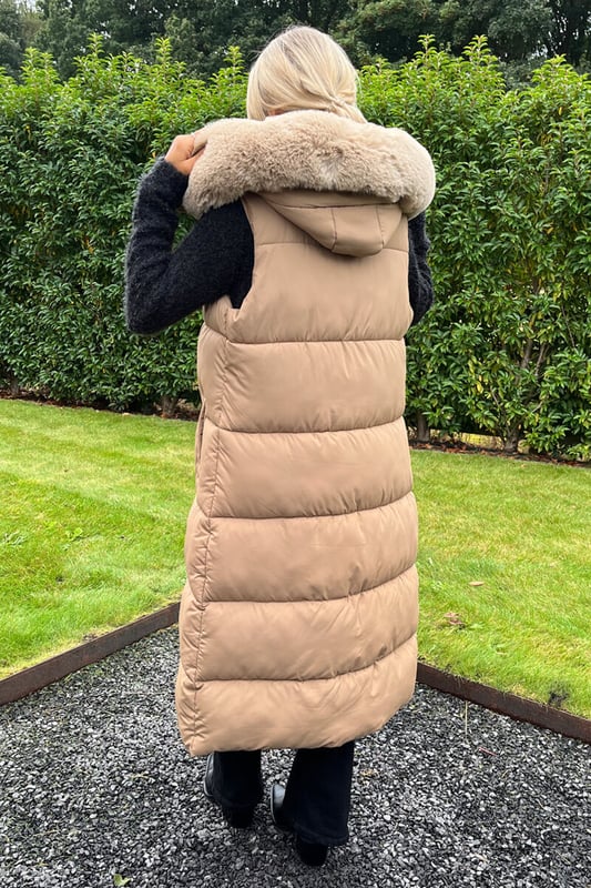 Feel cosy this winter in our Biscuit Faux Fur Hooded Longline Padded Gilet. Featuring a sleeveless design, a super soft beige faux fur hood with removable trim, all over padding, a double sided front zip and front pockets. Simply pair it with your favourite outfits to keep warm and on trend this season. Model wears: UK 8/ EU 36/ US 4 Model's height: 165cm/ 5'5" Approx length from centre back to hem: 110 cm Fabric composition: 100% Polyester Colour: BISCUIT