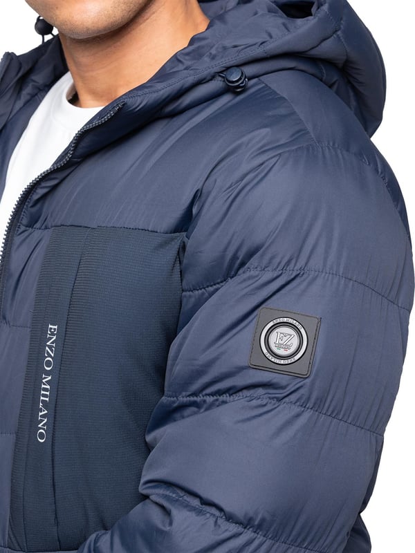 Bleiben Sie warm und stilvoll mit der Enzo Milano Herren Pufferjacke, die aus wasserabweisendem Material gefertigt ist, um Sie vor leichtem Regen und Wind zu schützen. Sie ist mit einer Brusttasche, zwei mit Reißverschluss versehenen Seitentaschen und einer einzelnen Innentasche mit Reißverschluss ausgestattet. Die charakteristische Enzo Milano Markenwerbung, einschließlich eines Metallabzeichens am Arm und einem Brustdruck, verleiht einen hochwertigen Touch. Die verstellbare Kordelzugkapuze und der Saum ermöglichen eine individuelle Passform, was diese Pufferjacke zu einer vielseitigen Wahl für den Alltag macht.