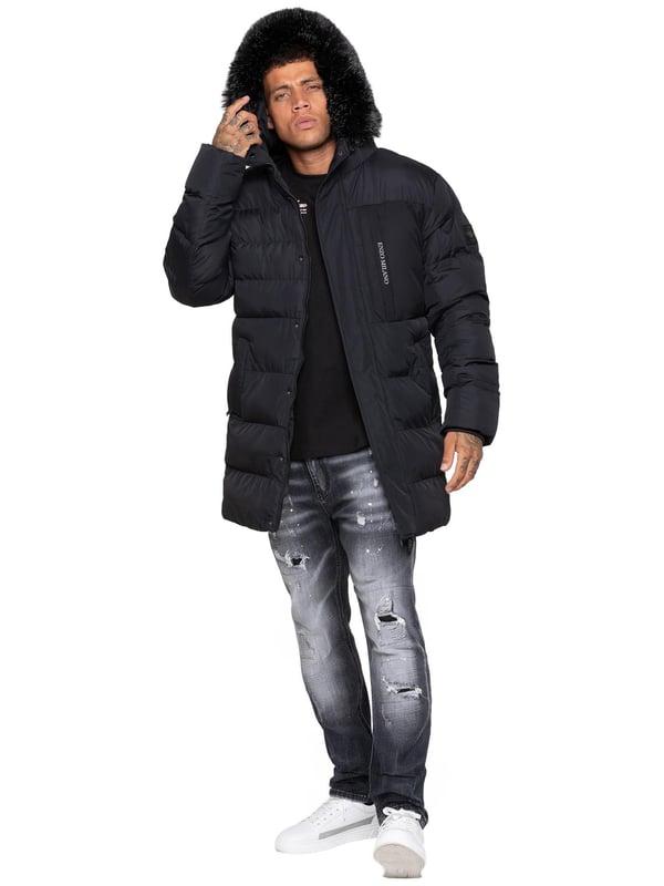Stay warm and protected with the Enzo Milano Men’s Longline Puffer Jacket, crafted from smooth water-resistant poly fabric and insulated with synthetic fill for lasting comfort. Designed with a detachable faux fur trim and a faux fur-lined hood. The chest print and signature metal badge on the arm add premium detailing, while multiple zip pockets – including waist, chest, and inner options – keep your essentials secure. A drawcord hood with adjustable toggle, ribbed cuffs, and a full zip fastening with popper buttons provide extra protection against wind and rain, making this longline puffer your ultimate cold-weather essential.