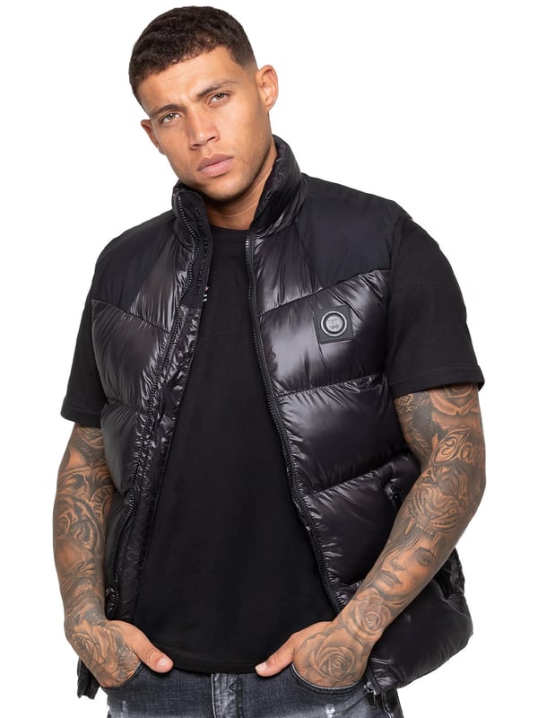 Heben Sie Ihre outerwear mit dem Enzo Milano Herren Puffer-Gilet hervor, das sowohl für Stil als auch für Praktikabilität entworfen wurde. Mit einem gestickten Enzo Milano-Logo am Reißverschluss-Schutz und einem eleganten Metallabzeichen auf der Brust bietet dieses Gilet einen Hauch von Luxus. Es wurde mit Blick auf Funktionalität gebaut und verfügt über zwei sichere seitliche Reißverschlusstaschen sowie eine einzelne Innentasche mit Reißverschluss, um Ihre Essentials sicher aufzubewahren. Der Kordelzug-Saum mit verstellbarem Stopper sorgt für eine individuelle Passform, während die glänzende Oberfläche ihm ein modernes, auffälliges Aussehen verleiht.