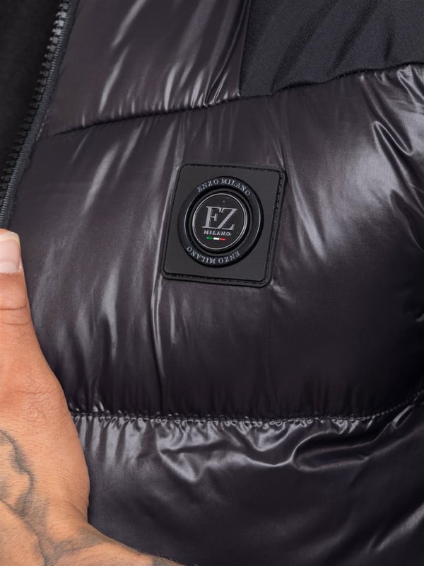 Heben Sie Ihre outerwear mit dem Enzo Milano Herren Puffer-Gilet hervor, das sowohl für Stil als auch für Praktikabilität entworfen wurde. Mit einem gestickten Enzo Milano-Logo am Reißverschluss-Schutz und einem eleganten Metallabzeichen auf der Brust bietet dieses Gilet einen Hauch von Luxus. Es wurde mit Blick auf Funktionalität gebaut und verfügt über zwei sichere seitliche Reißverschlusstaschen sowie eine einzelne Innentasche mit Reißverschluss, um Ihre Essentials sicher aufzubewahren. Der Kordelzug-Saum mit verstellbarem Stopper sorgt für eine individuelle Passform, während die glänzende Oberfläche ihm ein modernes, auffälliges Aussehen verleiht.