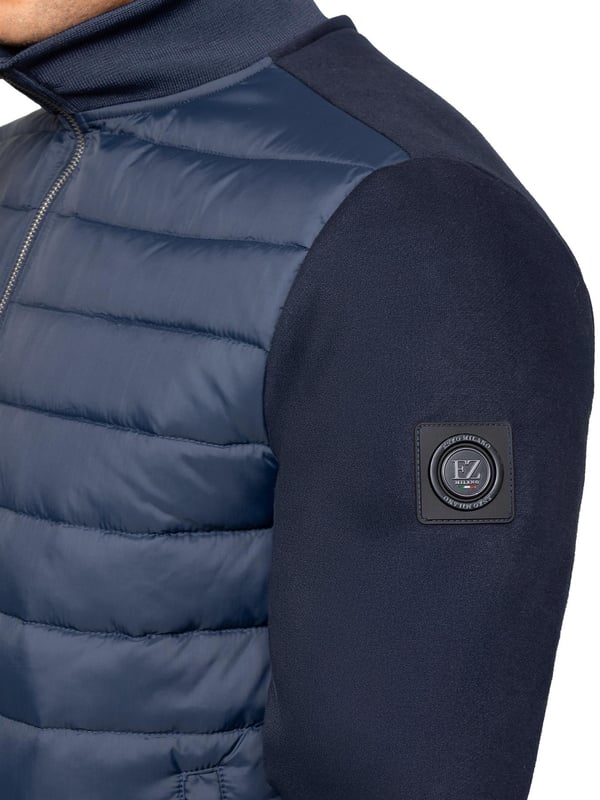 Verhoog je buitenkleding met de Enzo Milano Mannen Hybride Jas. Voorzien van een geribbelde kraag en een gewatteerd, waterafstotend polyamide voorpaneel. Het katoenen jersey rugpaneel en de mouwen zorgen voor flexibiliteit en ademend vermogen, terwijl geribbelde manchetten en een omgeslagen zoom een veilige pasvorm creëren. Praktische details zijn onder andere twee zijzakken met rits en opbergmogelijkheden aan de binnenkant. Afgewerkt met de kenmerkende Enzo Milano metalen badge op de linkerarm. (MJK47)
