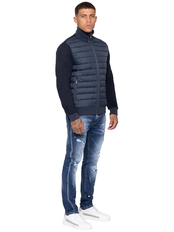 Verhoog je buitenkleding met de Enzo Milano Mannen Hybride Jas. Voorzien van een geribbelde kraag en een gewatteerd, waterafstotend polyamide voorpaneel. Het katoenen jersey rugpaneel en de mouwen zorgen voor flexibiliteit en ademend vermogen, terwijl geribbelde manchetten en een omgeslagen zoom een veilige pasvorm creëren. Praktische details zijn onder andere twee zijzakken met rits en opbergmogelijkheden aan de binnenkant. Afgewerkt met de kenmerkende Enzo Milano metalen badge op de linkerarm. (MJK47)