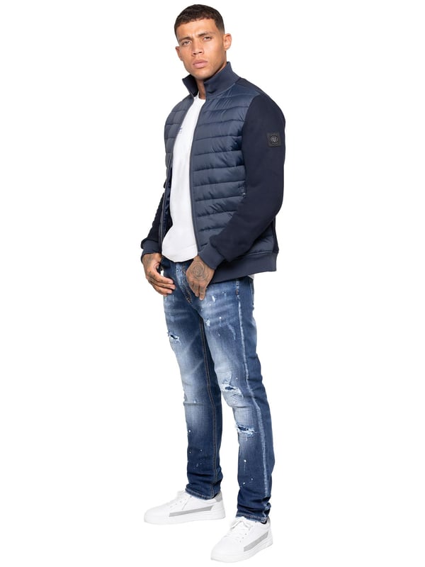 Verhoog je buitenkleding met de Enzo Milano Mannen Hybride Jas. Voorzien van een geribbelde kraag en een gewatteerd, waterafstotend polyamide voorpaneel. Het katoenen jersey rugpaneel en de mouwen zorgen voor flexibiliteit en ademend vermogen, terwijl geribbelde manchetten en een omgeslagen zoom een veilige pasvorm creëren. Praktische details zijn onder andere twee zijzakken met rits en opbergmogelijkheden aan de binnenkant. Afgewerkt met de kenmerkende Enzo Milano metalen badge op de linkerarm. (MJK47)