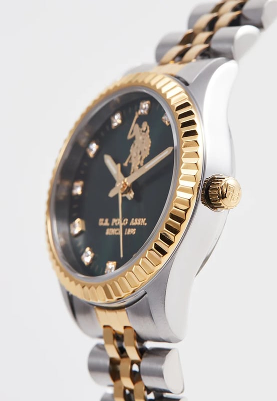 Quarzwerk (hohe Präzision)                      30 mm Edelstahlgehäuse                                   Gelbgold beschichtete Edelstahl-Lünette  Dunkelgrünes Sonnenschliff-Zifferblatt                                                                Edelstahlkrone / Edelstahl-Gehäuseboden                               Hochbeständiges Mineralglas                           Edelstahlband mit gelbgold beschichtetem Mittelglied und Edelstahl-Schließe         Wasserdicht bis 5 ATM