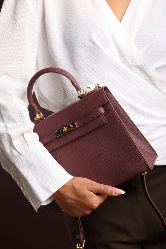 Elevate your everyday ensemble with this Lluvia Top Handle Satchel Mini Tote Bag, a timeless choice for modern elegance. Featuring a structured silhouette and refined grain-textured finish, this handbag blends style and practicality effortlessly. The polished gold-tone turn-lock closure adds a touch of sophistication. Ideal for work or weekend outings, it’s compact yet roomy enough for your essentials. Key Features: • Material: Textured faux leather with contrast stitching • Dimensions: 25cm (L) x 20cm (H) x 11cm (W) • Fastening: Gold-tone turn-lock flap closure • Detail: Minimalist top handle design with structured base and sleek finish