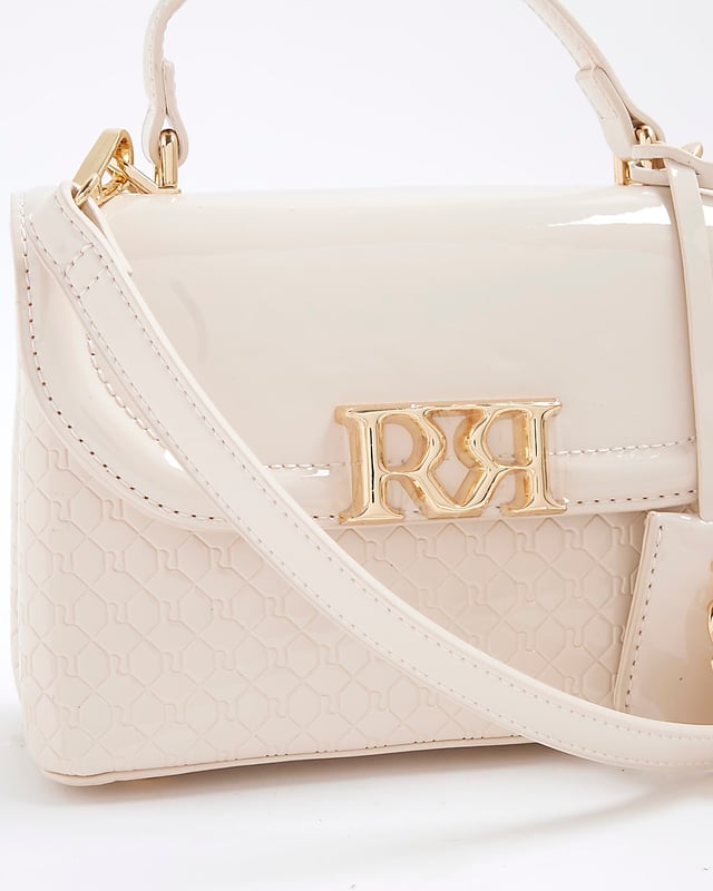 River Island Womens Tote Bag Cream Patent RI Flap Patent, RI monogram print, Grab handle, Detachable cross body strap, Charm detail, Gold branding, Interior zipped compartment, Front flap closure, Strap length: 60cm, H: 16cm x W: 24cm x D: 10cm