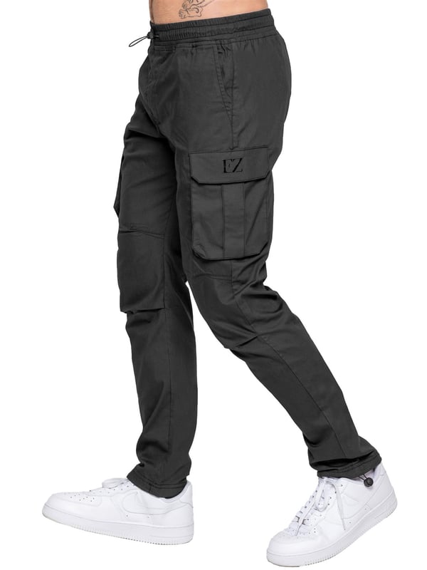 Upgrade your everyday style with the Enzo Men's Cargo Pants. Crafted from premium stretch fabric, these lightweight trousers offer a tapered leg fit for a sleek, modern look. Featuring an elasticated waistband with an adjustable toggle, they provide a customizable fit, while the adjustable toggle ankles let you tailor the look and feel. With two side slash pockets, two cargo pockets with secure Velcro fastening, and a single back welt pocket, you’ll have ample storage for essentials. Finished with an Enzo print on the cargo pocket. (649)