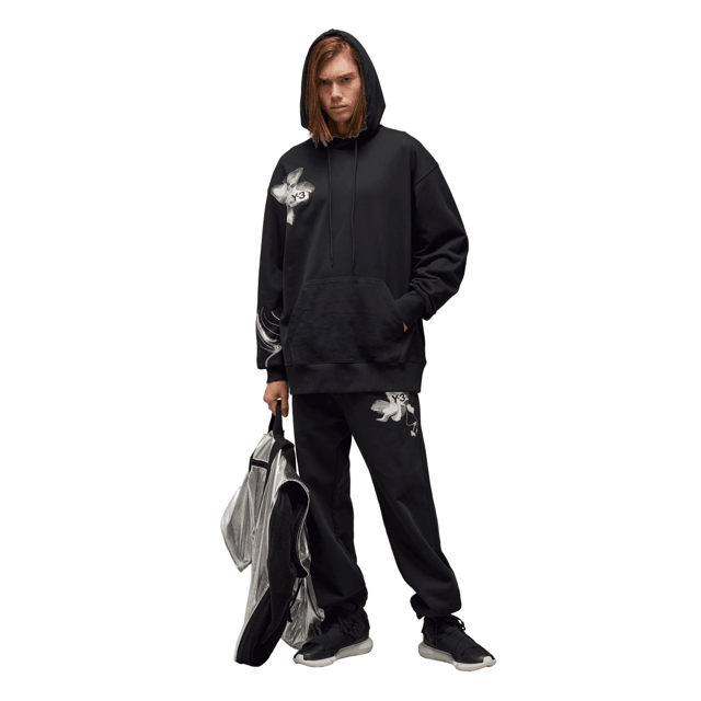 Y-3 Graphic French Terry Hoodie in black. The Y-3 Graphic French Terry Hoodie blends essential everyday wear with graphic style. An abstract floral print sits on the chest and wraps the sleeve. Cotton French terry fabricates a relaxed build  and a kangaroo pocket emphasises laid-back comfort.- A casual Y-3 hoodie.- Regular fit.- Drawcord-adjustable hood.- Long sleeves with drop shoulder.- Kangaroo pocket.- Ribbed cuffs and hem.- Y-3 logo.- 80% cotton  20% polyester (recycled).  Machine washable.- Ref: IN4335