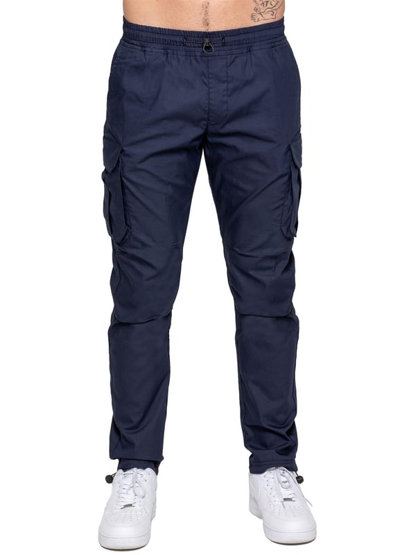 Upgrade your everyday style with the Enzo Men's Cargo Pants. Crafted from premium stretch fabric, these lightweight trousers offer a tapered leg fit for a sleek, modern look. Featuring an elasticated waistband with an adjustable toggle, they provide a customizable fit, while the adjustable toggle ankles let you tailor the look and feel. With two side slash pockets, two cargo pockets with secure Velcro fastening, and a single back welt pocket, you’ll have ample storage for essentials. Finished with an Enzo print on the cargo pocket. (649)