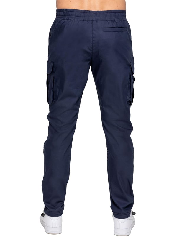 Upgrade your everyday style with the Enzo Men's Cargo Pants. Crafted from premium stretch fabric, these lightweight trousers offer a tapered leg fit for a sleek, modern look. Featuring an elasticated waistband with an adjustable toggle, they provide a customizable fit, while the adjustable toggle ankles let you tailor the look and feel. With two side slash pockets, two cargo pockets with secure Velcro fastening, and a single back welt pocket, you’ll have ample storage for essentials. Finished with an Enzo print on the cargo pocket. (649)