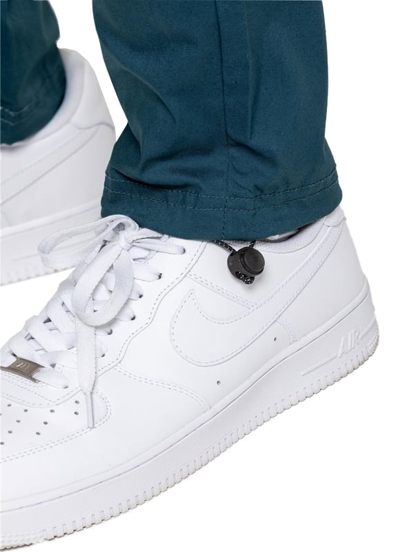 Bringe deinen Alltagsstil auf das nächste Level mit der Enzo Herren-Cargohose. Gefertigt aus hochwertigem Stretchstoff, bietet diese leichte Hose eine schmal zulaufende Passform für einen eleganten, modernen Look. Der elastische Bund mit verstellbarem Kordelzug ermöglicht eine individuelle Passform, während die verstellbaren Kordelzüge an den Knöcheln das Aussehen und Tragegefühl anpassbar machen. Mit zwei seitlichen Eingrifftaschen, zwei Cargotaschen mit sicherem Klettverschluss und einer einzelnen Paspeltasche hinten hast du ausreichend Platz für deine Essentials. Abgerundet mit einem Enzo-Print auf der Cargotasche.