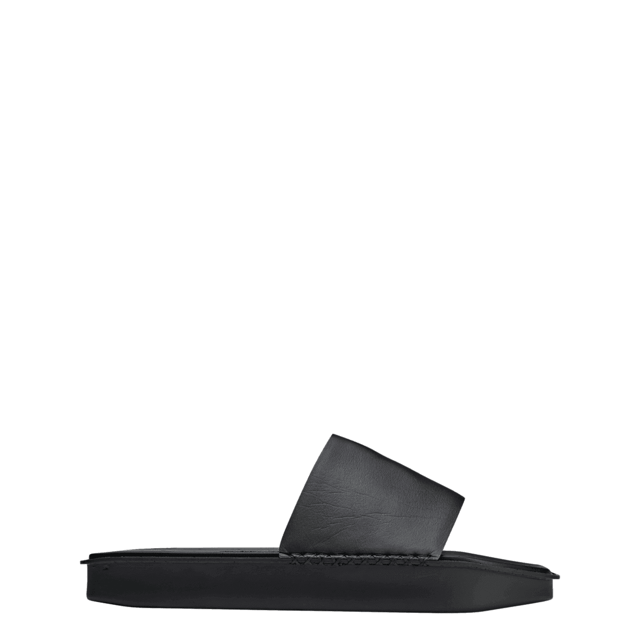 Y-3 Water Slides in zwart.Handgemaakte details accentueren het minimalistische ontwerp van de Y-3 Water Slides. Het EVA voetbed met textuur is gemaakt met opzettelijke onregelmatigheden bovenop. De buitenzool knipoogt naar de beroemde adidas Adilette slides en is afgewerkt met Yohji's handtekening aan de onderkant. Minimalistische Y-3 slides met verrassende textuur.- Slip-on.- Polyurethaan bovenkant.- Synthetisch suède achterkant op bovenkant.- EVA voetbed.- Y-3 logo.- Ref: FZ6423