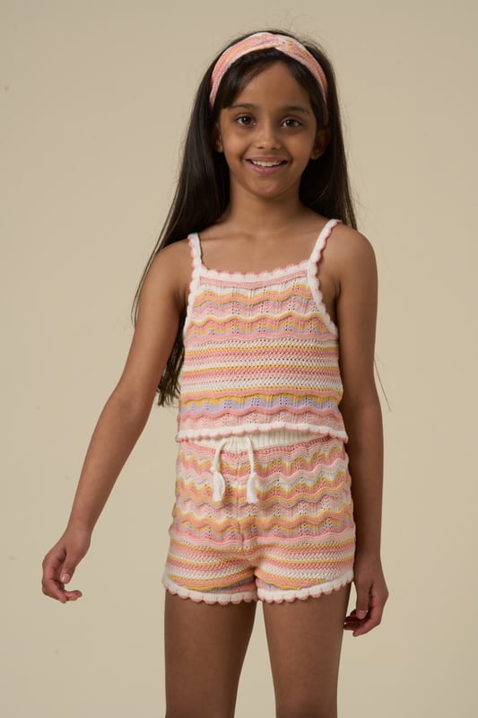 This adorable set by Miss includes a true knit top, comfy shorts, and a matching headband. Perfect for warm days, it combines style and practicality, making it an ideal choice for playdates, outings, or casual summer looks.
