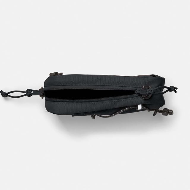 Mens Timberland Crossbody Bag in black.- Large zipper opening into main compartment.- Front panel slip pocket with bungee system and reflective details.- Adjustable shoulder strap.- Mesh back panel.- 2 ways of wearing.- Woven stacked logo badge.- Ref: A5SSY0011
