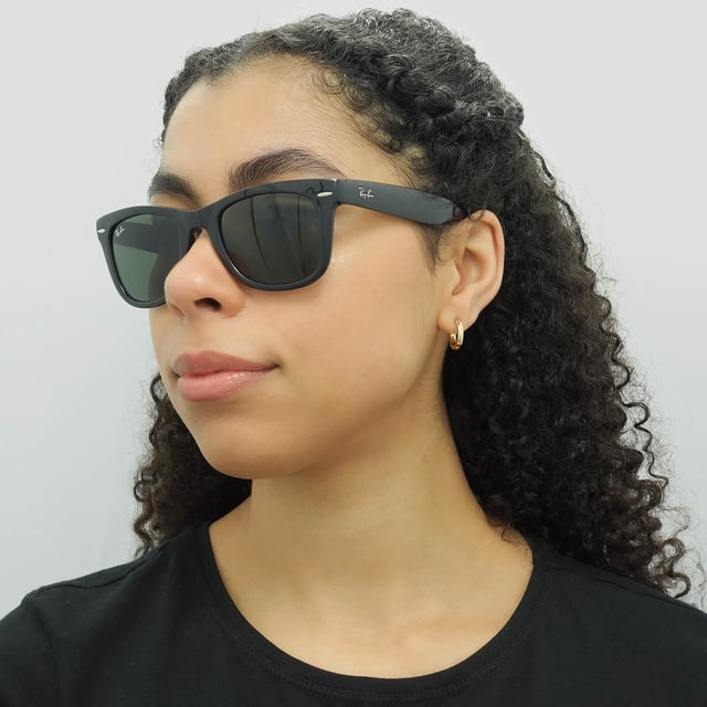 Ray-Ban Sunglasses Folding Wayfarer 4105 Black 601 50mm are a folding version of one of the most recognisable and bestselling sunglass styles worldwide and are enormously popular among celebrities, musicians and artists. The distinctive angled design and thick frame are sure to make a statement and Ray-Ban are constantly using vibrant colours and patterns to update this classic and popular style. The lightweight acetate frame is comfortable and the Ray-Ban logo is displayed on the corner of the lens in addition to the sculpted winged temples. They fold in the bridge and in the middle of the temples to give a compact finish that folds nicely into a suitable sized pouch for easy storage.