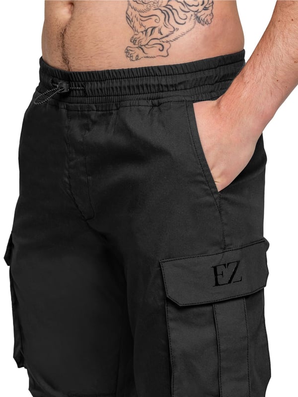 Upgrade your everyday style with the Enzo Men's Cargo Pants. Crafted from premium stretch fabric, these lightweight trousers offer a tapered leg fit for a sleek, modern look. Featuring an elasticated waistband with an adjustable toggle, they provide a customizable fit, while the adjustable toggle ankles let you tailor the look and feel. With two side slash pockets, two cargo pockets with secure Velcro fastening, and a single back welt pocket, you’ll have ample storage for essentials. Finished with an Enzo print on the cargo pocket. (649)