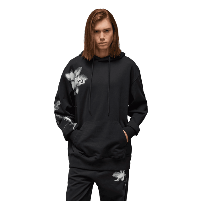 Y-3 Graphic French Terry Hoodie in black. The Y-3 Graphic French Terry Hoodie blends essential everyday wear with graphic style. An abstract floral print sits on the chest and wraps the sleeve. Cotton French terry fabricates a relaxed build  and a kangaroo pocket emphasises laid-back comfort.- A casual Y-3 hoodie.- Regular fit.- Drawcord-adjustable hood.- Long sleeves with drop shoulder.- Kangaroo pocket.- Ribbed cuffs and hem.- Y-3 logo.- 80% cotton  20% polyester (recycled).  Machine washable.- Ref: IN4335