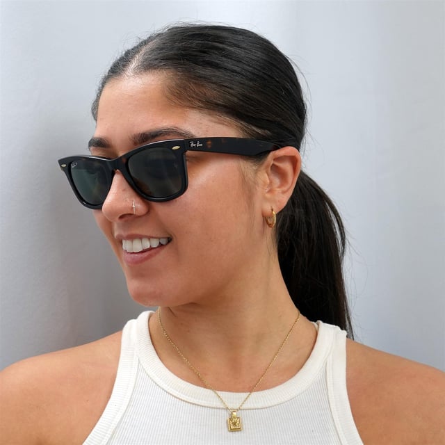 Las gafas de sol Ray-Ban Wayfarer 2140 Tortoise Green G-15 polarizadas medianas de 50 mm son uno de los estilos de gafas de sol más conocidos y vendidos en todo el mundo, y son muy populares entre famosos, músicos y artistas. Su distintivo diseño angular y su montura gruesa son toda una declaración de estilo, y Ray-Ban utiliza constantemente colores y diseños vibrantes para actualizar este estilo clásico y popular. La ligera montura de acetato es cómoda y el logotipo de Ray-Ban aparece junto a las patillas aladas esculpidas en la esquina de la lente.